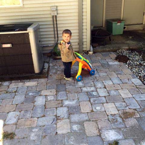 grandson playing on paver patio